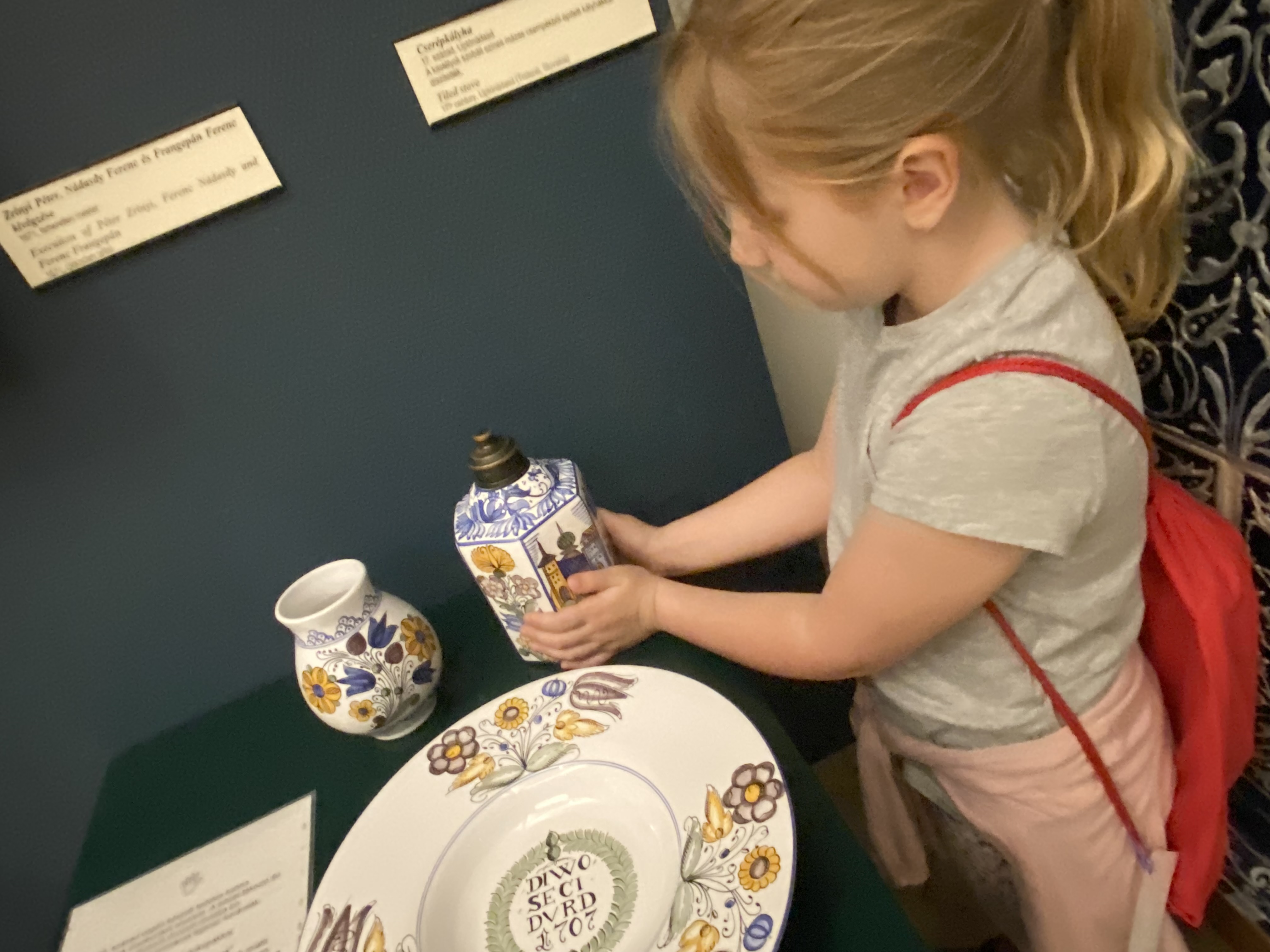 kislány múzeumban porcelán tárgyakkal